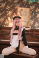 A woman with pink hair sitting on a piano.